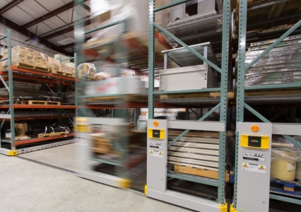 A warehouse scene with an ActivRAC mobile system in motion, organizing multiple pallets.
