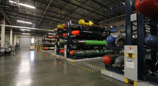 Warehouse filled with various equipment and torpedoes stored in ActivRAC system.