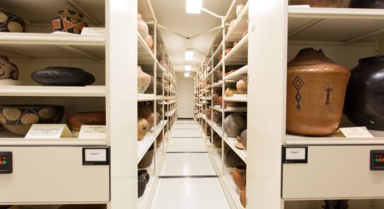 A museum high-density mobile storage system displaying an array of pots and vases.