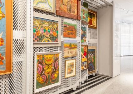 A room filled with an assortment of paintings displayed on art racks, creating a visually captivating atmosphere.