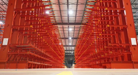 Spacious warehouse with red cantilever racking.
