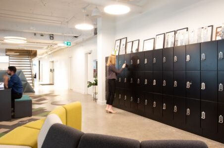 Spacesaver day use lockers in an office, alongside a stylish yellow couch.