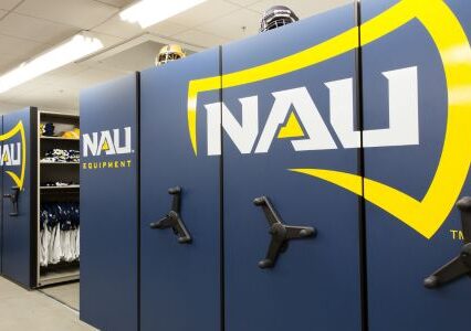 Sporting equipment in locker room with Spacesaver mobile storage system & blue/yellow logo.
