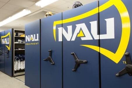 Sporting equipment in locker room with Spacesaver mobile storage system & blue/yellow logo.