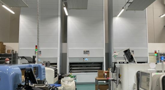 A factory with machines and people working in it, featuring 3 Modula slim systems.