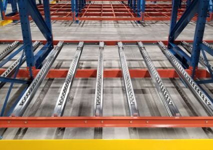 A warehouse showcasing a pallet flow racking system, featuring a spacious metal rack for efficient storage.
