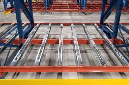 A warehouse showcasing a pallet flow racking system, featuring a spacious metal rack for efficient storage.