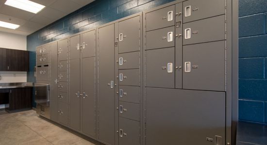 Blue-walled room with pass-through evidence lockers.