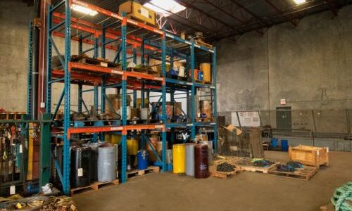Blue and orange racking system in warehouse storing rigging equipment.