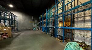 Warehouse with blue racking system installed on the back wall.