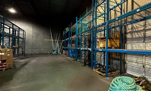 Warehouse with blue racking system installed on the back wall.