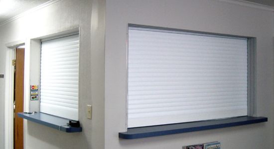 Office room with two white shutters on wall.