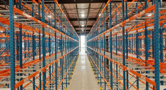 A warehouse with orange selective racking, ensuring efficient inventory management.