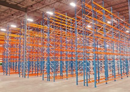 A spacious warehouse showcasing vibrant orange and blue racks featuring a selective racking system.
