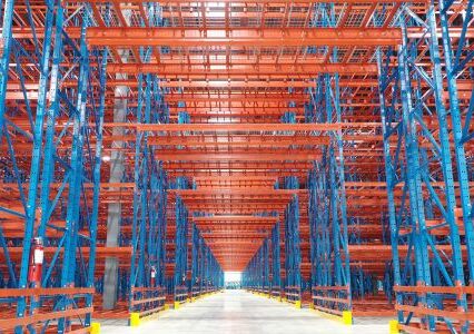 A warehouse with rows of shelves organized in a structural racking system, providing efficient storage.