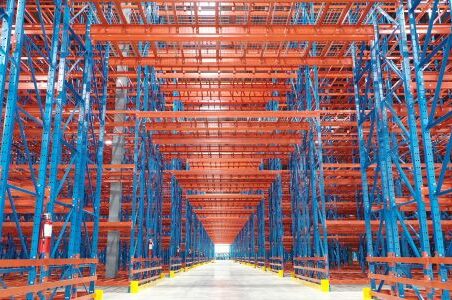 A warehouse with rows of shelves organized in a structural racking system, providing efficient storage.