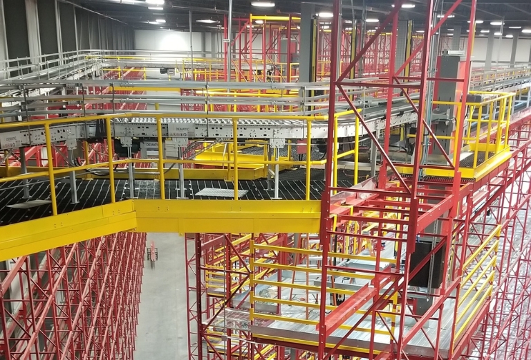 Aerial view of a large warehouse with a red structural racking system with integrated elevators.