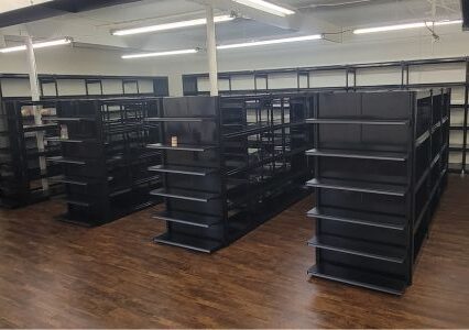 Spacious room with black trim-line shelves and wooden floors.