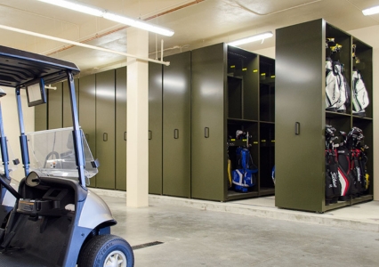 A golf cart alongside a Wheelhouse® Mobile Storage unit containing various golf bags and equipment.