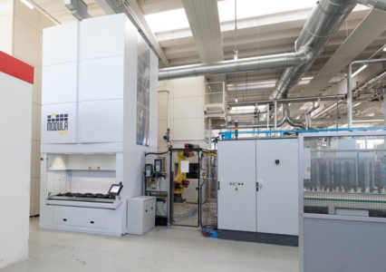 A Modula Lift vertical storage system with an open access bay stands in a clean industrial facility