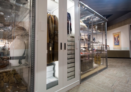 A museum room featuring a Viking Preservation Cabinet displaying clothing and artifacts.