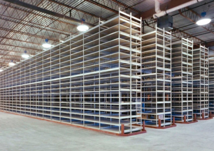 A large warehouse filled with rows of tall, empty E-Z-Rect Type 1 shelving units under industrial lighting.