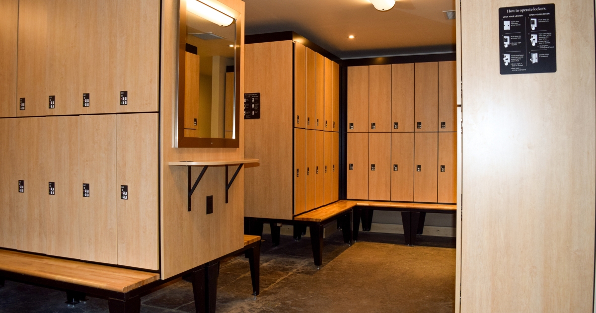 Hi-Cube-Storage-Day-Use-Lockers Large wellness locker room showcasing light wood day use lockers and benches for guests’ convenience
