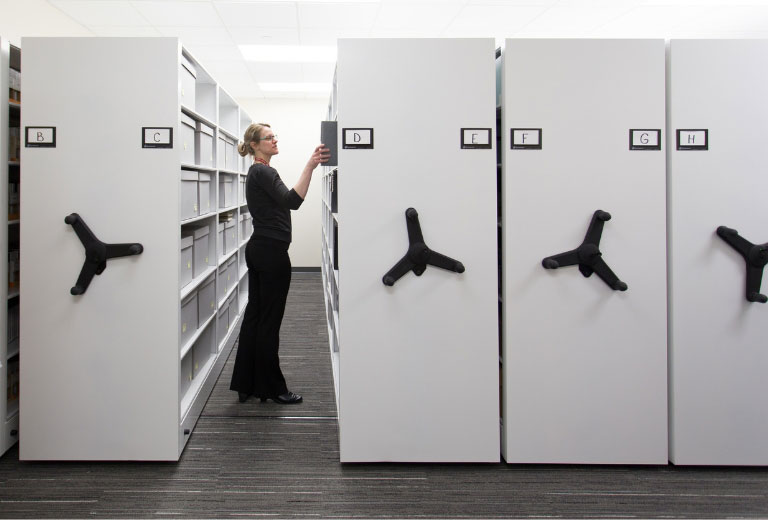 Women in office searching for files in a mobile storage system.