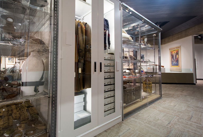 A museum room featuring a Viking Preservation Cabinet displaying clothing and artifacts.