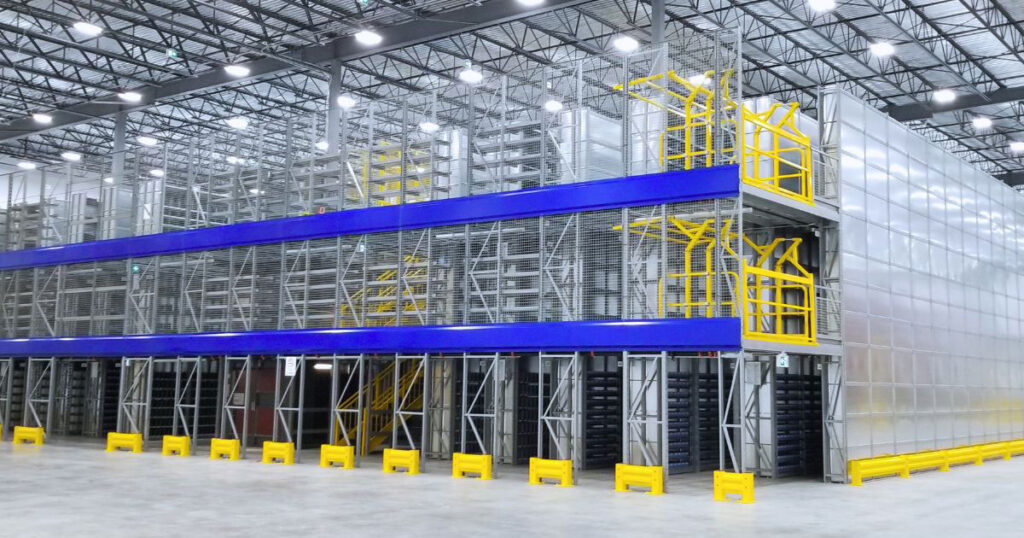 Multi-tier catwalk mezzanine integrated with high-density shelving and safety mesh barriers, featuring upper-level access gates and floor guardrails.