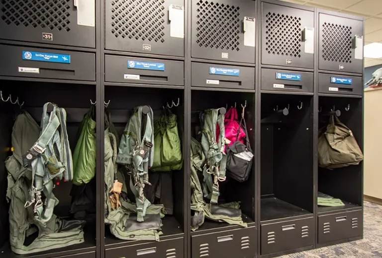 A row of black FreeStyle® Personal Storage Lockers with open compartments displaying military gear.